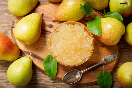 bowl of pear jam and fresh fruits on a wooden table, top viewの写真素材