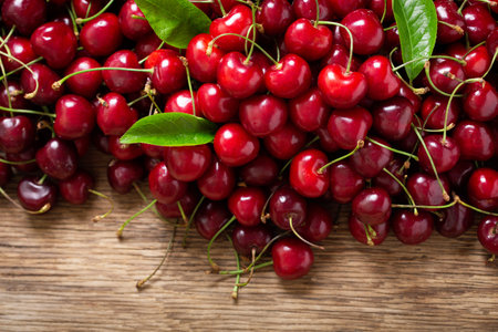 fresh ripe cherries on a wooden table, top view