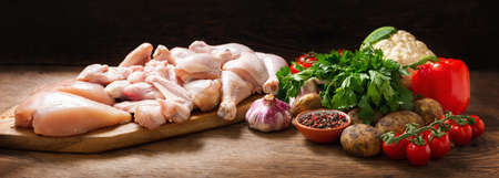 fresh chicken meat and ingredients for cooking on a wooden tableの写真素材