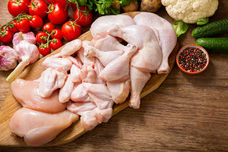fresh chicken meat with vegetables on a wooden table, top viewの写真素材