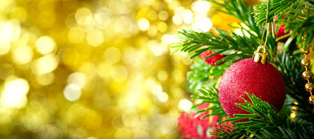 Christmas and New Year background. Christmas tree decorated with red balls on branch of fir on blurred backgroundの写真素材