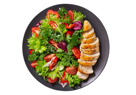plate of chicken salad with vegetables isolated on white background, top viewの写真素材