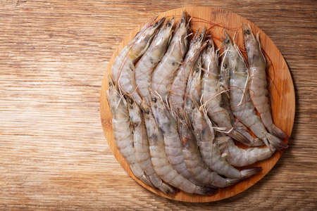 fresh shrimps on a wooden board, top viewの写真素材