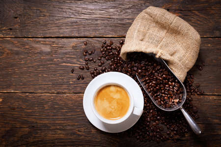 cup of coffee and coffee beans on a wooden background, top viewの写真素材