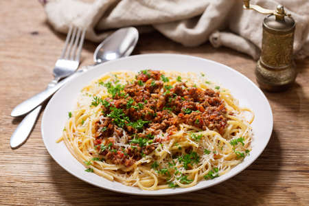 plate of pasta bolognese on a wooden tableの写真素材
