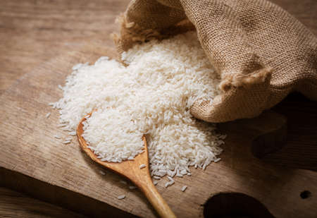 Close up of raw white rice on a wooden boardの写真素材