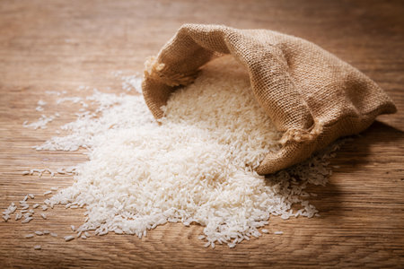 Close up of raw white rice on a wooden tableの写真素材