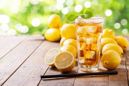 Lemon iced tea with fresh fruits on a wooden tableの写真素材