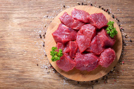 fresh chopped meat with parsley and spices on wooden background, top viewの写真素材