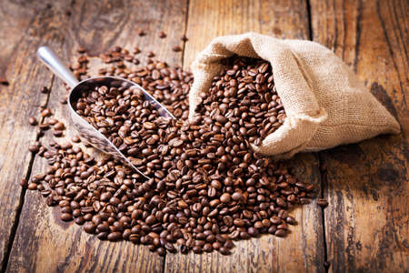 close up of coffee beans in a sack on a wooden tableの写真素材