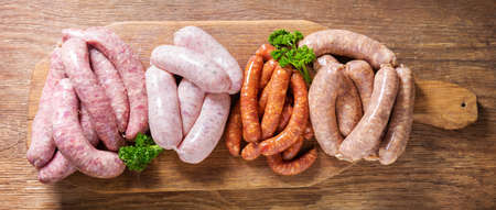 various kind of types of fresh sausages on chopping board, top viewの写真素材