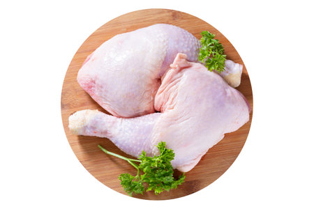fresh chicken legs with parsley on a wooden board isolated on white background, top viewの写真素材