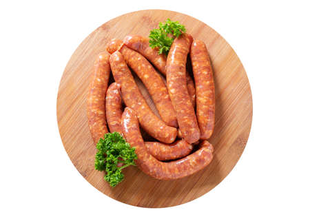 Fresh sausages on a chopping board isolated on white background, top viewの写真素材
