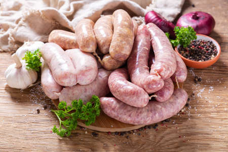 various kind of types of fresh sausages with spices on chopping boardの写真素材