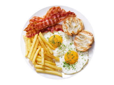 plate of fried eggs, bacon, french fries and toast isolated on white background, top viewの写真素材