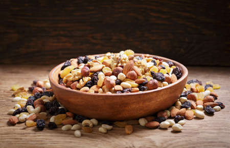 bowl of mixed nuts with dried fruits on wooden backgroundの写真素材