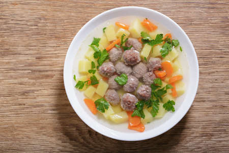 plate of soup with meatballs on wooden background, top viewの写真素材
