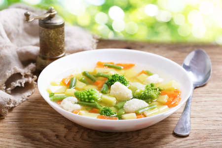 plate of vegetable soup on wooden tableの写真素材