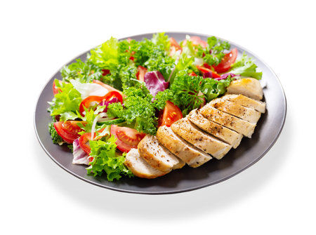 plate of salad with chicken and vegetables isolated on white backgroundの写真素材