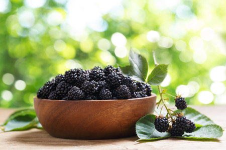 bowl of ripe blackberries on wooden tableの写真素材