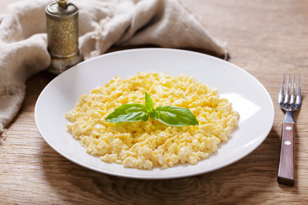 plate of scrambled eggs on wooden tableの写真素材
