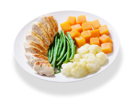 plate of grilled chicken and vegetables isolated on white backgroundの写真素材