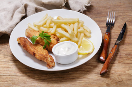 plate of fish and chips on wooden tableの写真素材