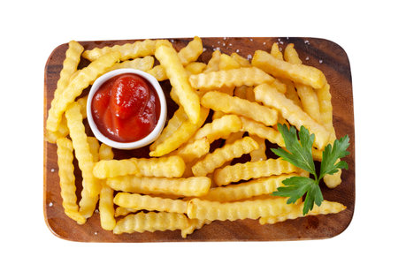 French fries with ketchup on a wooden board isolated on white background, top viewの写真素材