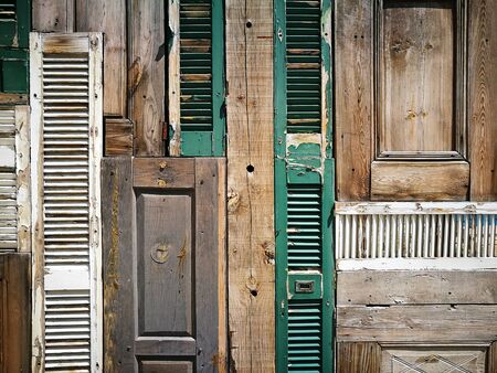 Old wooden doors and window shutters on a facade in the old town of Alacati in the province of Izmir in Turkeyの写真素材