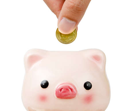 Hand putting money to piggy bank close upの写真素材