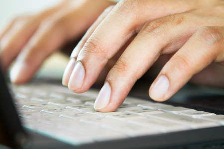 Male hands using a laptopの写真素材