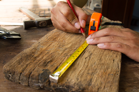Architect measure plank wood and marking with pencil for building interior furnitureの写真素材
