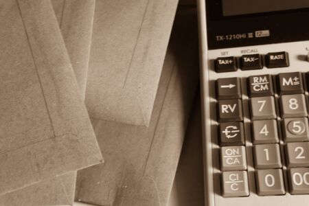 envelop and calculator, sepia tone,の写真素材