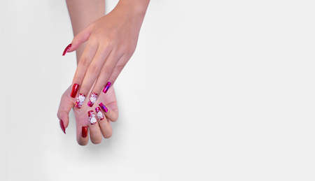 sparkling red color gel polish painting 3D rose flower decorate d with shiny rhinestone and glitter on fashionista woman long square shape acrylic fingernail isolated on white background with copy spaceの写真素材