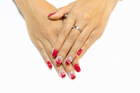 Woman hand manicure painting dark pink gel polish decorated with silver pink glitter omber design isolated on White backgroundの写真素材