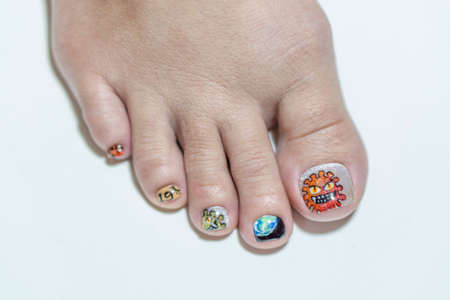close up woman short toenail painting multicolor gel nails art in coronavirus 19 concept isolate on white backgroundの写真素材