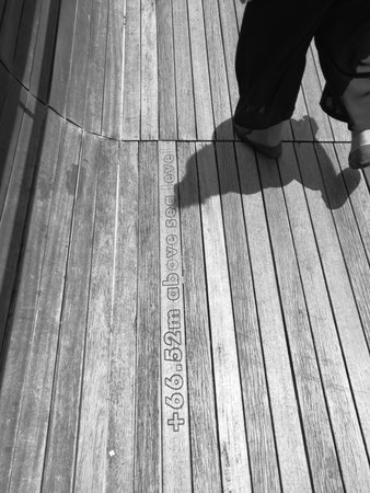 Close Up on foot of walking people on wooden floors, black and white.