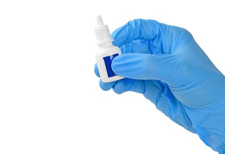 Human hand in medical glove is holding medicine or eye drop container isolated on white backgroundの写真素材