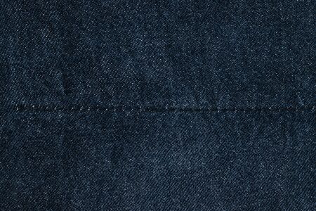 Texture details of dark blue jeans, textile with stitches for background.の写真素材