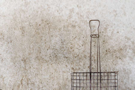Old steel grid for grill on dirty cement wall in kitchen with copy space.の写真素材