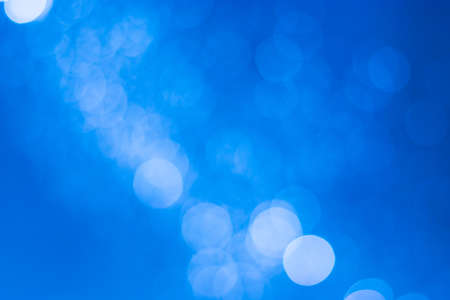 Abstract bokeh, defocused of water drops reflects light on light blue background.の写真素材