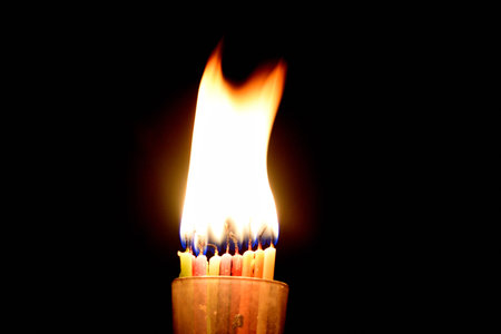 Burning candle on a black background. Close-up image.の写真素材