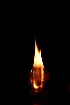 Burning candle on a black background. Fire in the dark.の写真素材
