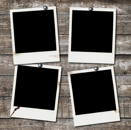 Four blank photos on wooden wallの写真素材