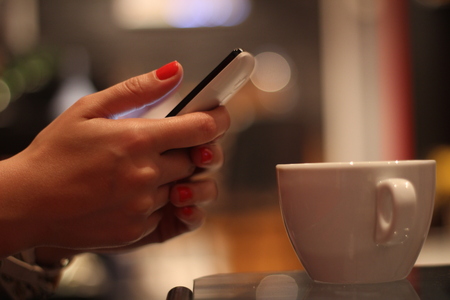 Girl drinking coffee and browsing the internetの写真素材