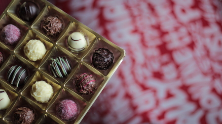 Chocolate candy box on a decorative red and white tableclothの写真素材