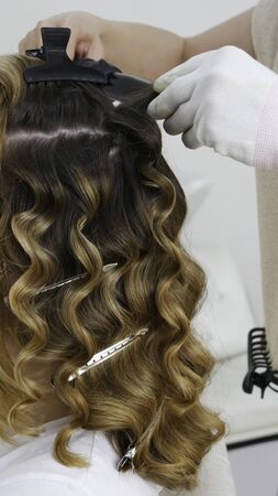 Making a hairstyle in the hair salon - close upの写真素材