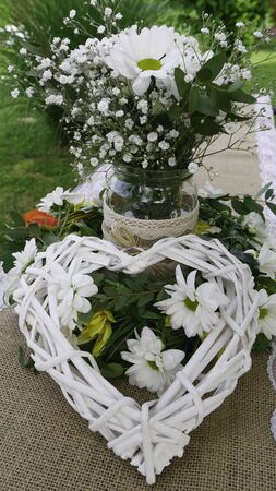 White daisy bouquet in glass jar and wattle white heart in green.の写真素材