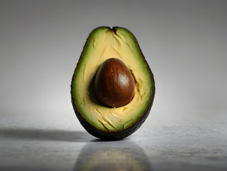Avocado cut in half with seed on white background. Close up.の素材