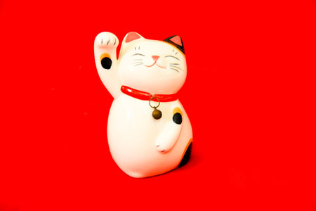 maneki neko lucky cat on red backgroundの写真素材